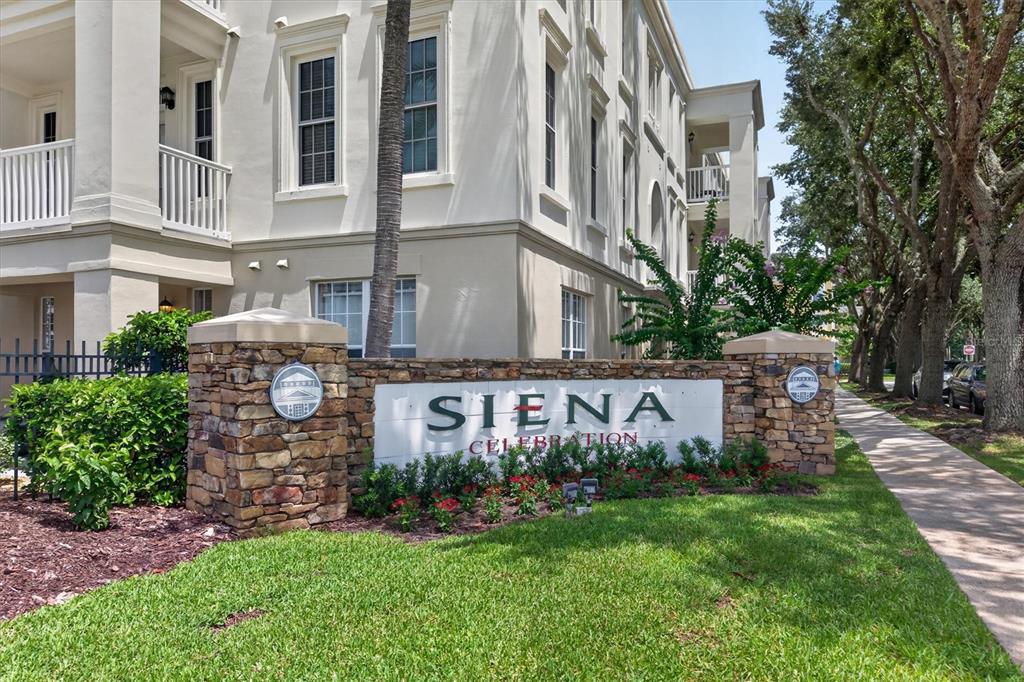The exterior of a multi-story apartment building features a stone monument sign reading Siena Celebration — 730 SIENA PALM DRIVE UNIT 104, CELEBRATION, FL