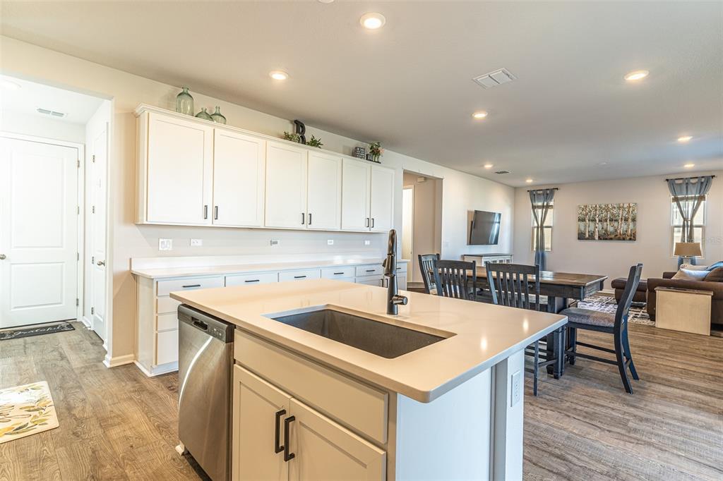 A kitchen with white cabinets, a central island with a sink, and an adjacent dining area — 1123 SUGARWOOD STREET, DAVENPORT, FL