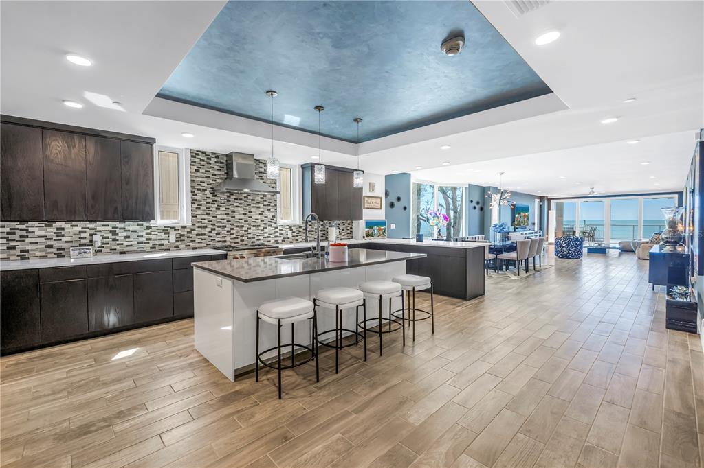 A modern kitchen with dark cabinets, a white island, and a blue tray ceiling — 19816 GULF BOULEVARD UNIT 201, INDIAN SHORES, FL