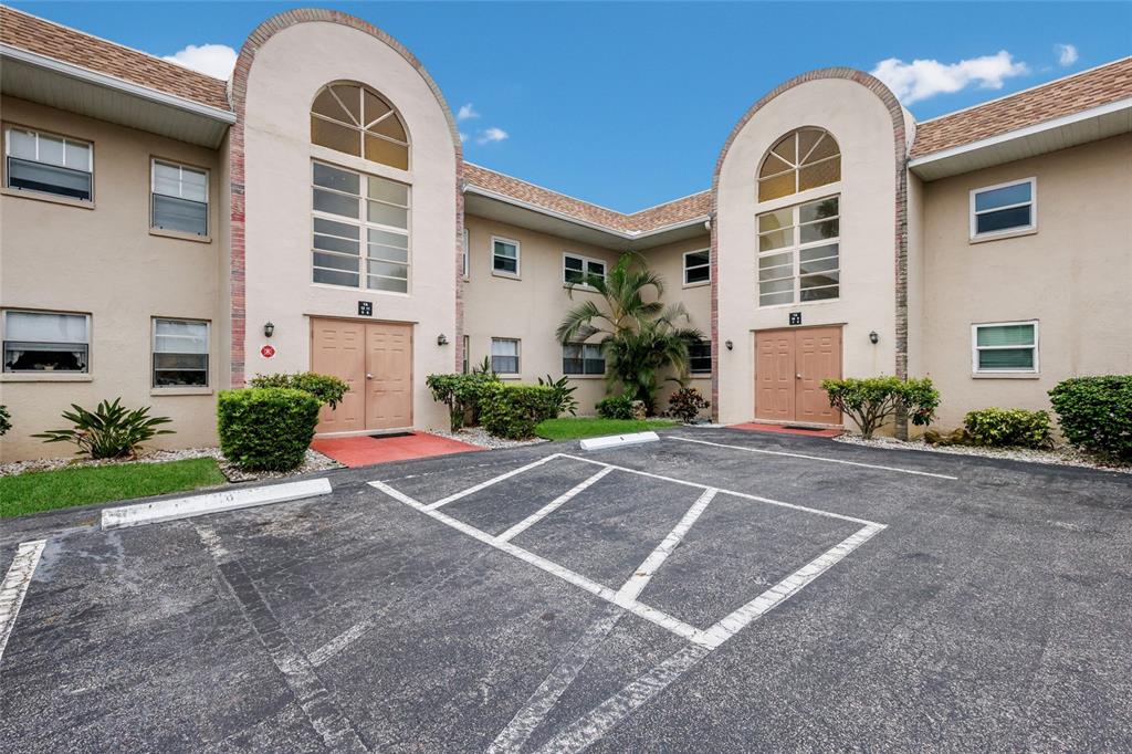 An exterior view of a two-story apartment building with a parking lot in front — 2727 75TH STREET W UNIT 7A11, BRADENTON, FL