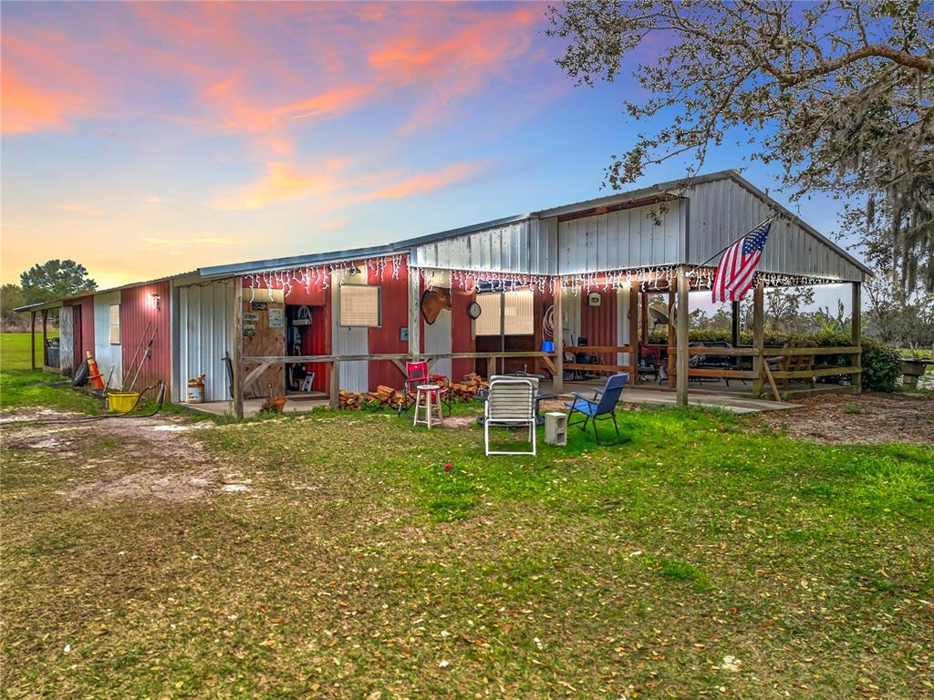 A red and white metal barn with a covered porch and an American flag — 41204 EMERALDA ISLAND ROAD, LEESBURG, FL