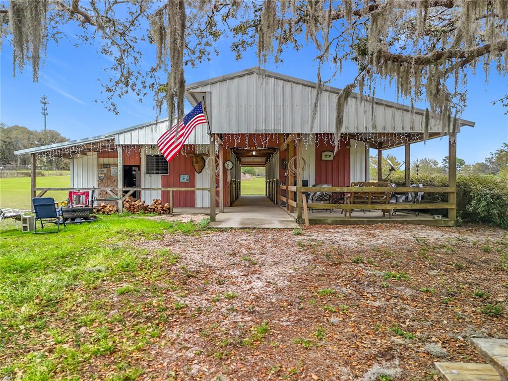 A red and white barn with a covered porch and an American flag — 41204 EMERALDA ISLAND ROAD, LEESBURG, FL