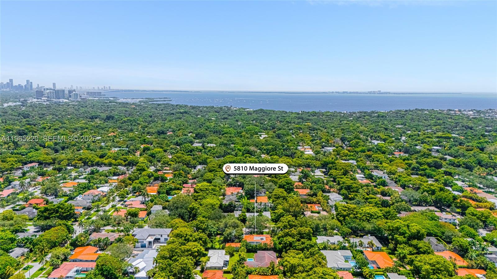 An aerial view shows a residential neighborhood densely covered with trees near a large bay — 5810 Maggiore St # 0, Coral Gables FL 33146, CORAL GABLES, FL