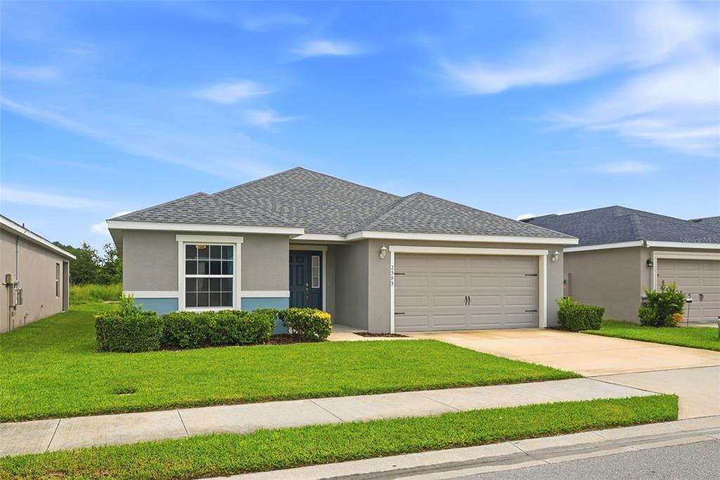 A single-story house with a gray exterior, a two-car garage, and a manicured front lawn — 2595 SAN MARCO WAY, WINTER HAVEN, FL