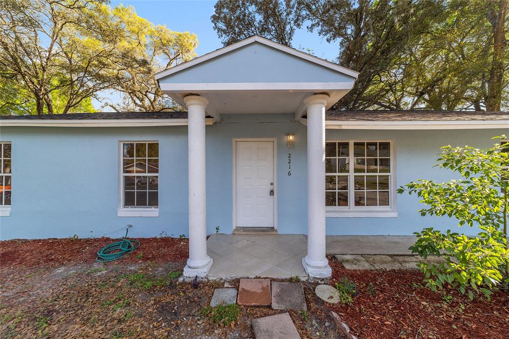 A galley kitchen features wood cabinets, butcher block countertops, stainless steel appliances, and tile flooring — 2216 NE 38TH STREET, OCALA, FL