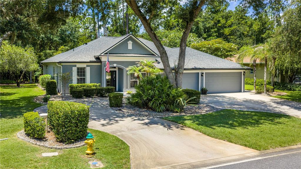 A single-story gray house with a two-car garage, a paved driveway, and a front lawn — 3412 REXFORD CIRCLE, ORMOND BEACH, FL