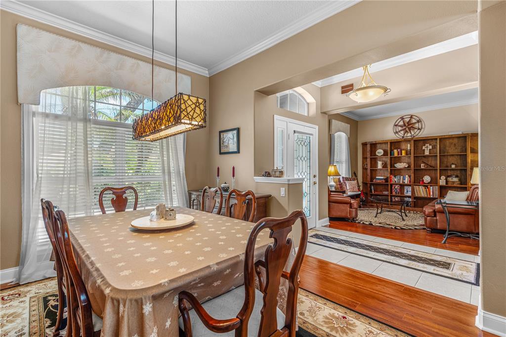 A dining room with a wooden table and chairs leads into a living area — 3412 REXFORD CIRCLE, ORMOND BEACH, FL