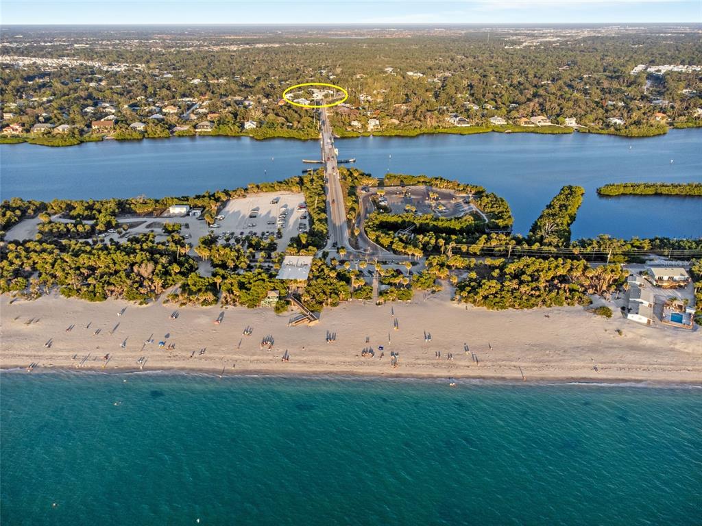 Aerial view of a beach, parking lot, and bridge leading to a residential area — 1730 MANASOTA BEACH ROAD UNIT 207, ENGLEWOOD, FL
