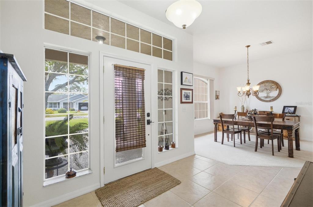 A tiled entryway features a front door with a transom window and a dining area — 21 WOODSHIRE LANE, PALM COAST, FL
