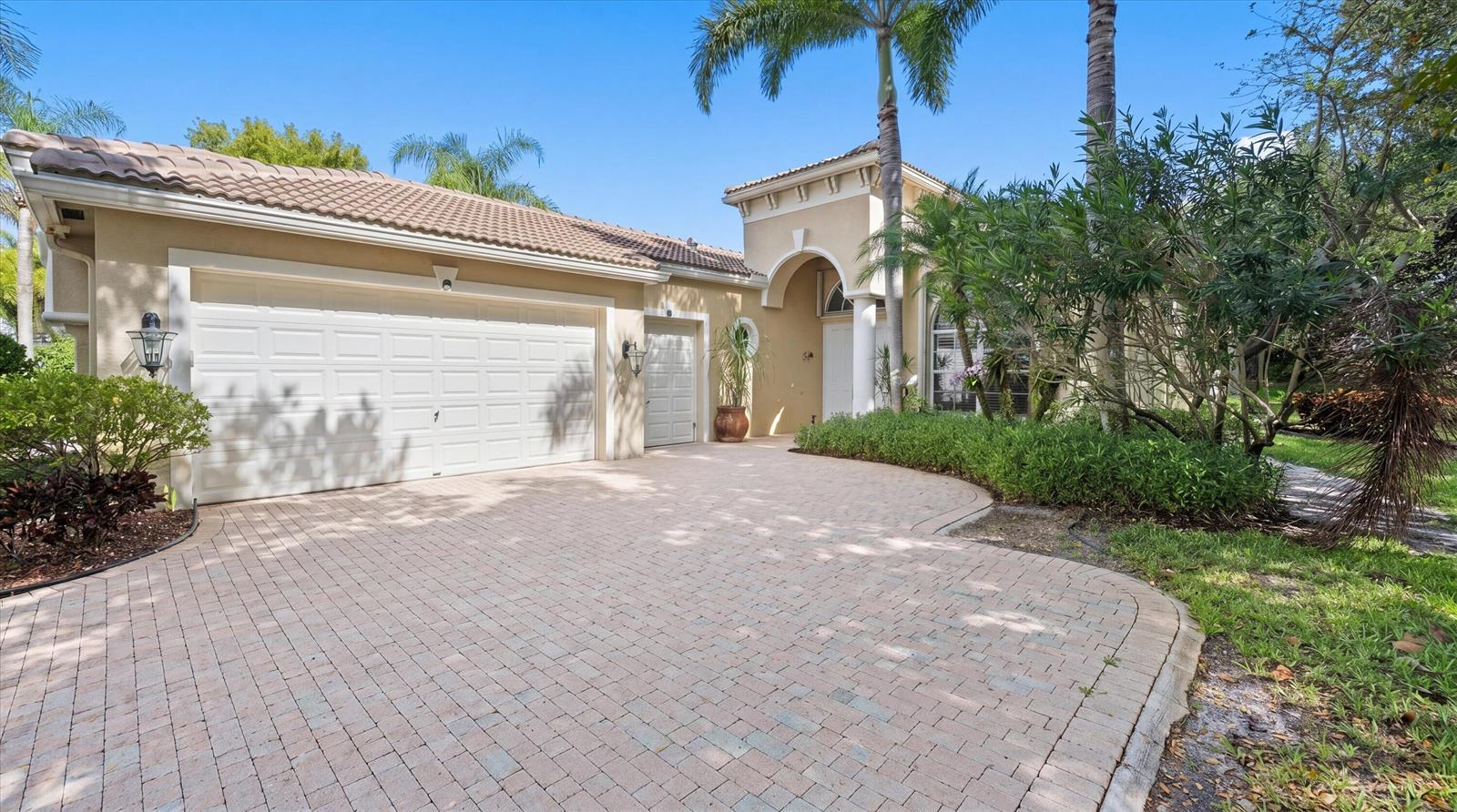 A beige house with a tiled roof, a paved driveway, and a two-car garage — 10689 Northgreen Drive, Lake Worth FL 33449, LAKE WORTH, FL