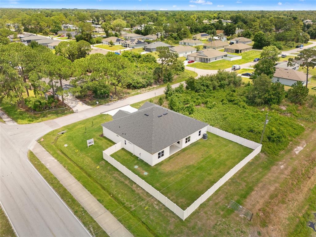 An aerial view shows a single-story house with a fenced backyard in a suburban neighborhood — 1406 VALERIUS STREET SE, PALM BAY, FL