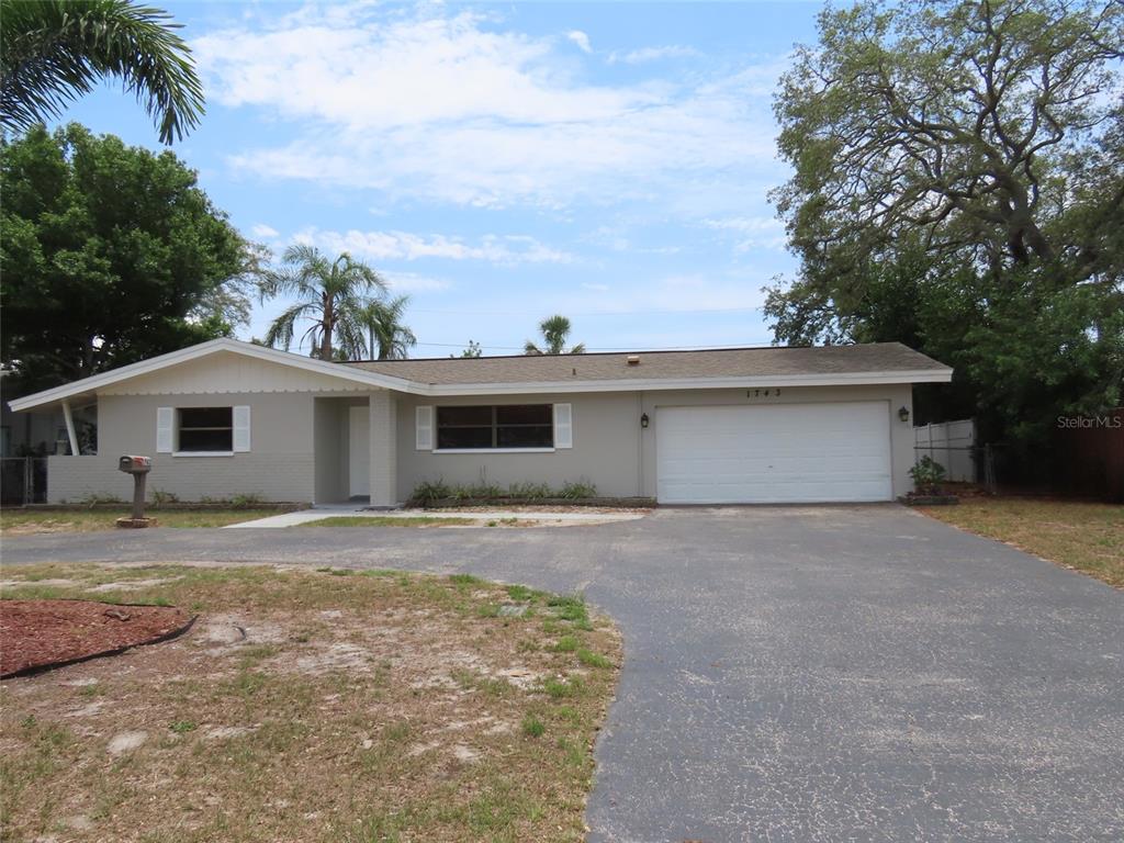 A single-story house with a gray exterior, white trim, and an attached two-car garage — 1743 SUNSET POINT ROAD, CLEARWATER, FL