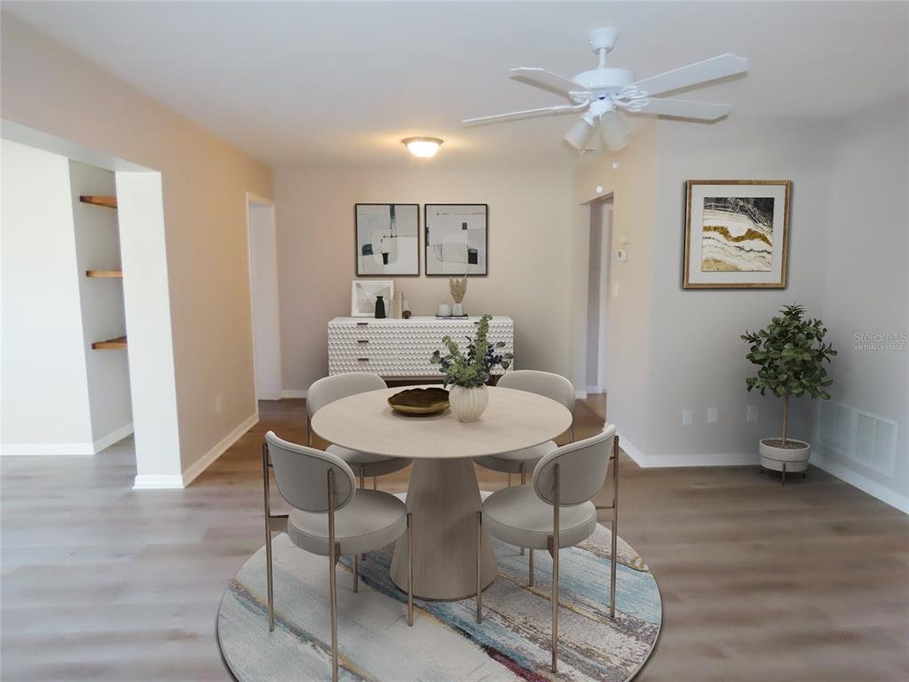 A dining room features a round table, four chairs, a sideboard, and a ceiling fan — 1743 SUNSET POINT ROAD, CLEARWATER, FL