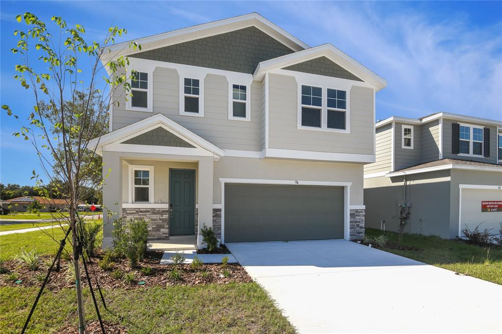 A two-story suburban house with a gray garage, light siding, and a stone-accented entryway — 716 LAKE DELL AVENUE, DUNDEE, FL