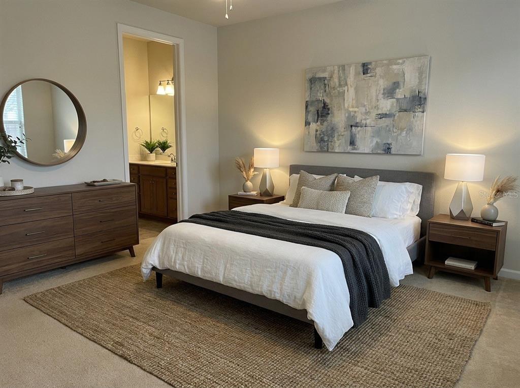A bedroom features a bed with a dark throw, two nightstands, and a wooden dresser — 9831 DEL WEBB PARKWAY UNIT 4208, JACKSONVILLE, FL