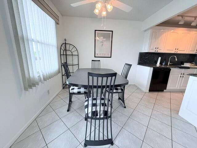 A dining area features a black table and chairs with checkered cushions near a kitchen — 4065 Harwood E, Deerfield Beach FL 33442, DEERFIELD BEACH, FL