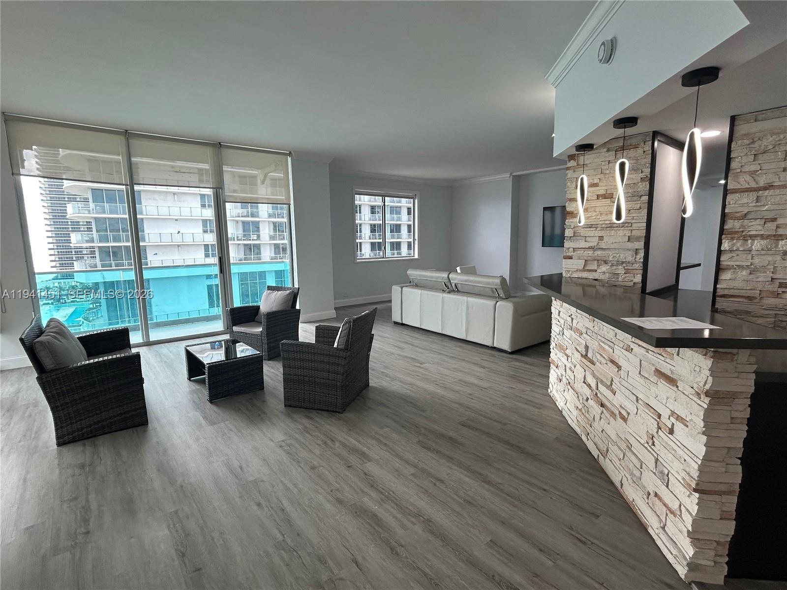 A dining room features a glass table, eight white chairs, and a modern ceiling fan — 4001 S Ocean Dr, Hollywood FL 33019, HOLLYWOOD, FL