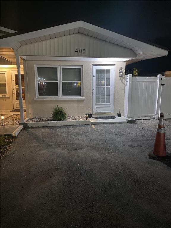 The exterior of a single-story building features a white door, a window, and a driveway — 405 S ORION AVENUE, CLEARWATER, FL