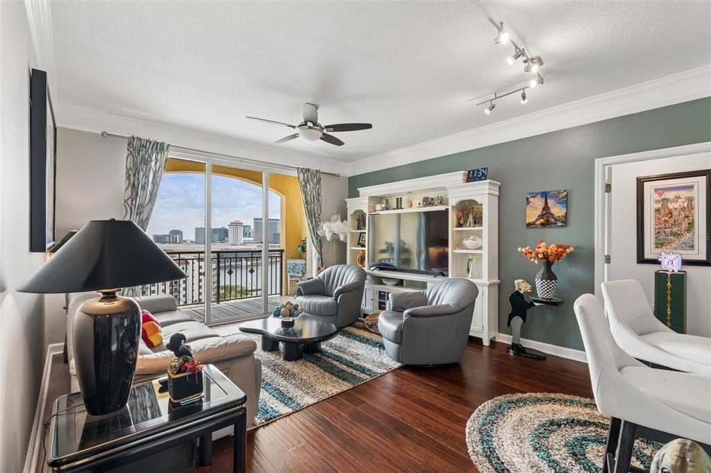 A living room features hardwood floors, a white entertainment center, and a balcony with city views — 345 BAYSHORE BOULEVARD UNIT 1206, TAMPA, FL