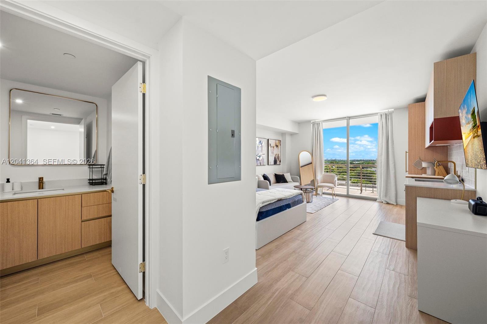 A studio apartment features a bathroom, kitchenette, bed, and a balcony with a view — 90 NE 32nd St # 925, Miami FL 33137, MIAMI, FL