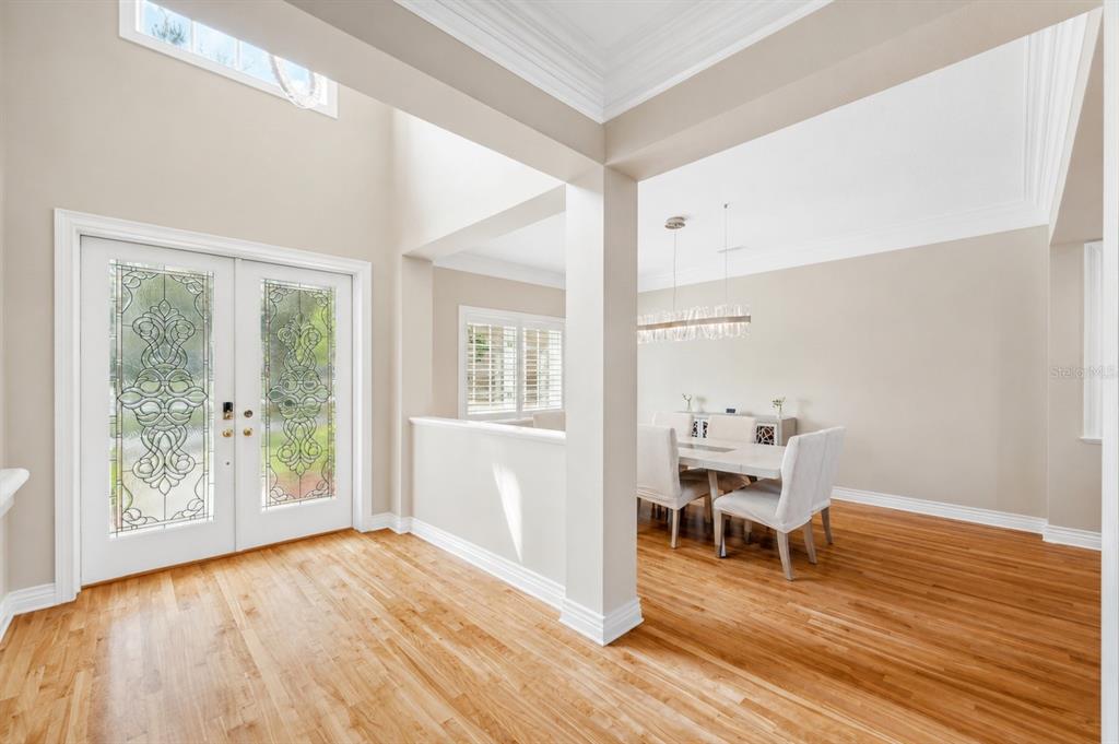An entryway with hardwood floors leads to a dining area with a half wall — 2280 MACKENZIE COURT, CLEARWATER, FL