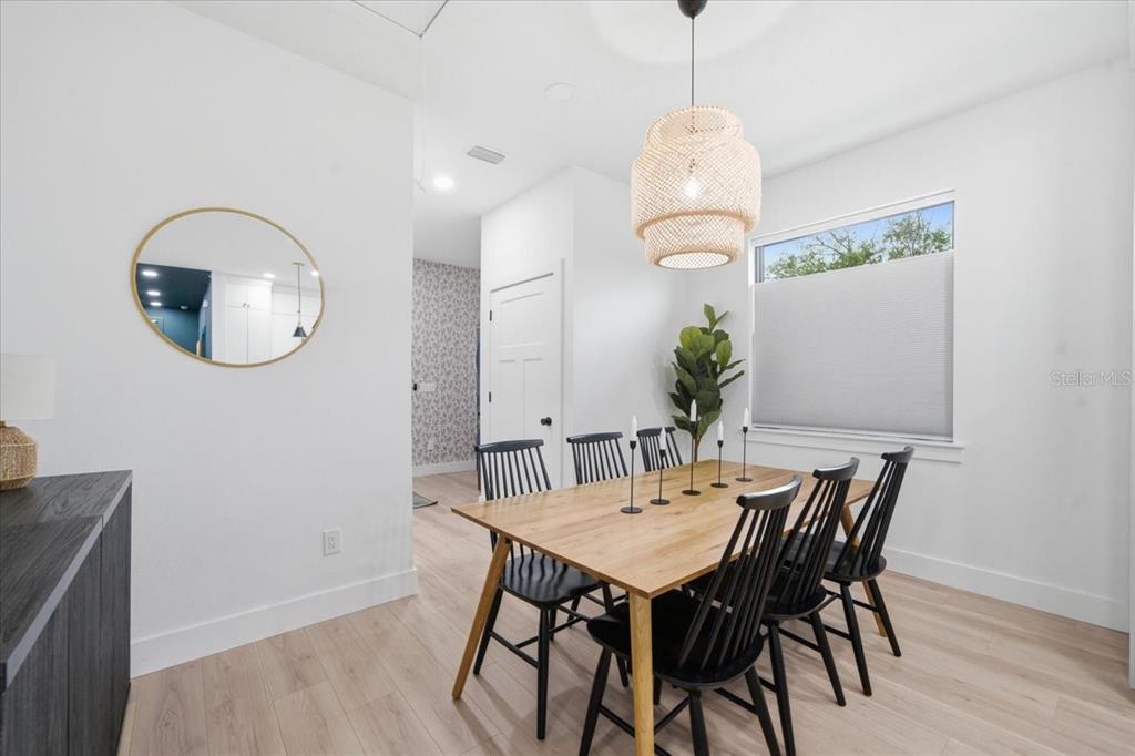 A dining room features a wooden table, black spindle chairs, and a woven pendant light — 2601 E 24TH AVENUE, TAMPA, FL