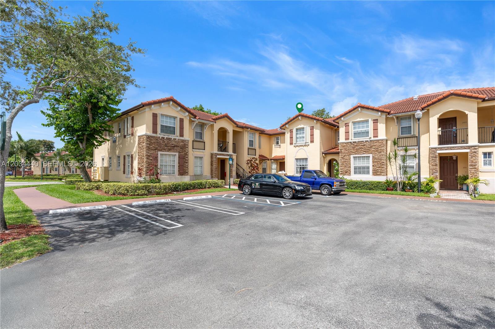 A two-story apartment building with a parking lot and two parked vehicles in front — 1490 NE 33rd Rd # 18, Homestead FL 33033, HOMESTEAD, FL