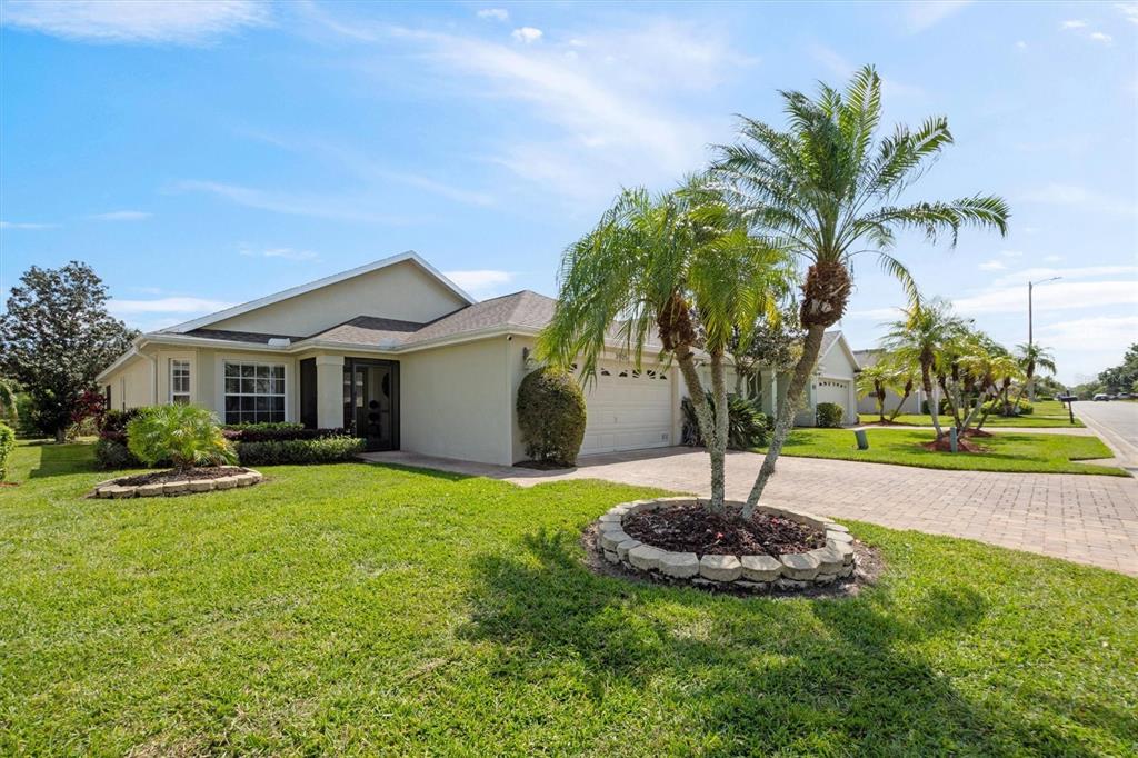 A single-story house with a paved driveway, a palm tree, and a green lawn — 3905 OSPREY POINTE CIRCLE, WINTER HAVEN, FL