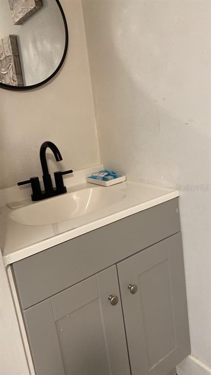 A living area features a black refrigerator, a coffee table, a side table, and wall art — 9921 VAUGHN STREET UNIT 2 Bd, GIBSONTON, FL