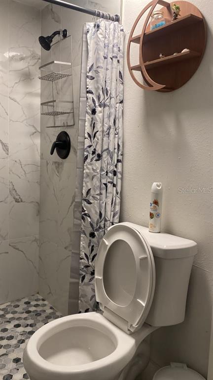 A small room features a dark blue sofa, a gray coffee table, and two wall paintings — 9921 VAUGHN STREET UNIT 2 Bd, GIBSONTON, FL