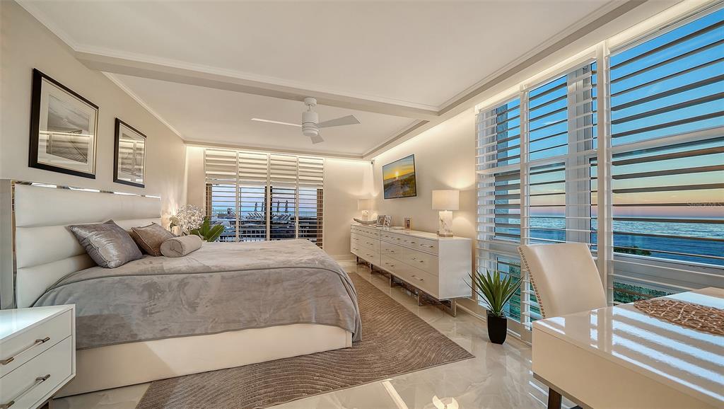 A bedroom features a white bed, a long dresser, and large windows overlooking the ocean — 2301 GULF OF MEXICO DRIVE UNIT 12N, LONGBOAT KEY, FL