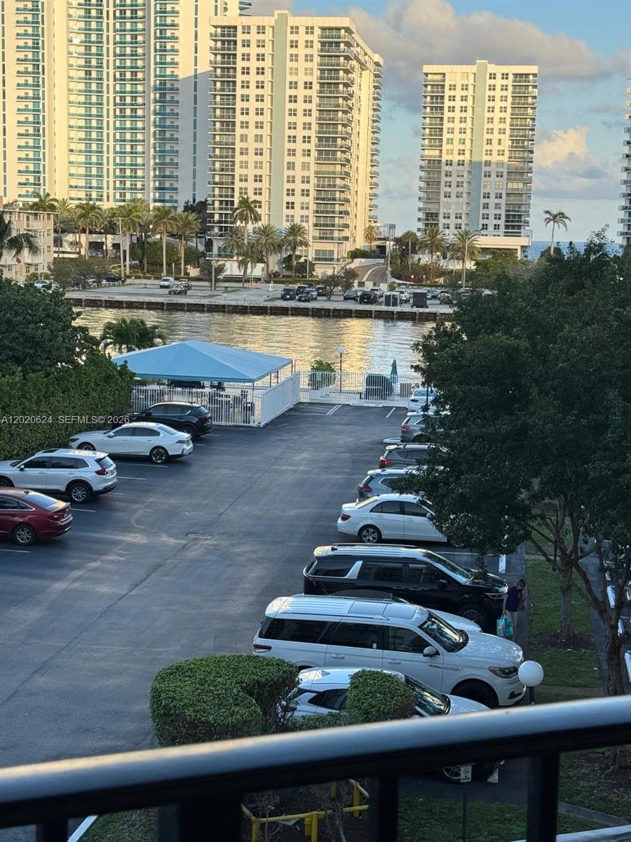 An elevated view of a parking lot next to a waterway with high-rise buildings beyond — 800 Parkview Dr # 406, Hallandale Beach FL 33009, HALLANDALE BEACH, FL