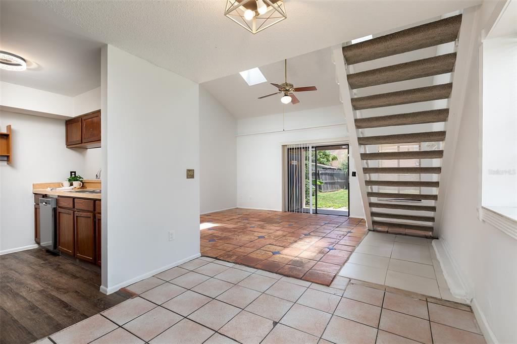 A kitchen and living area with tile flooring, a staircase, and a sliding glass door — 2745 TALLY HO AVENUE, ORLANDO, FL