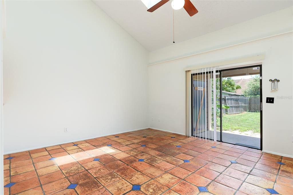 A room with vaulted ceilings, terracotta tile flooring with blue accents, and a sliding glass door — 2745 TALLY HO AVENUE, ORLANDO, FL