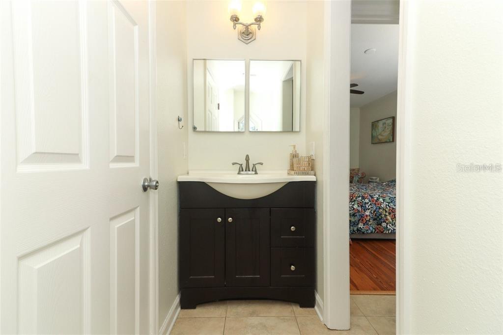 A bathroom vanity with a dark cabinet and white countertop sits between two doorways — 1442 PALM AVENUE, WINTER PARK, FL