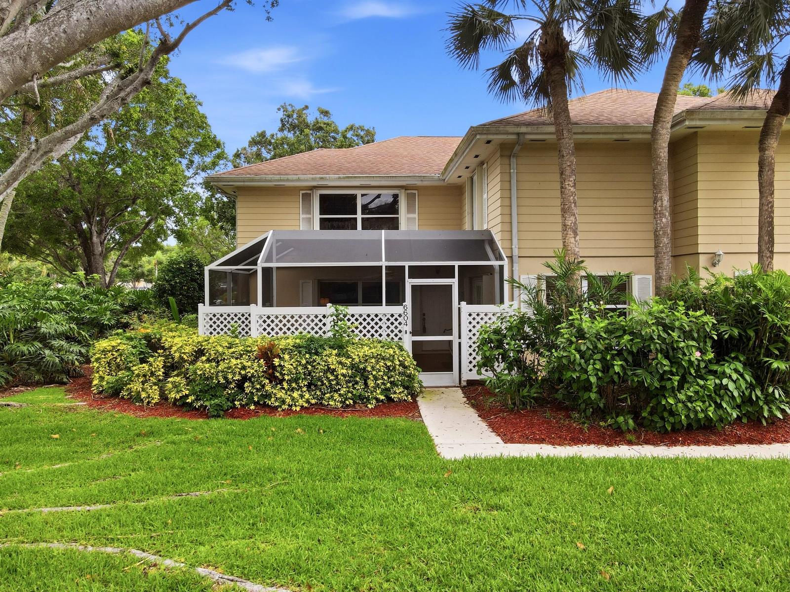 A two-story tan house features a screened-in patio with white lattice and a front lawn — 6604 Dryden Court # D, Boynton Beach FL 33436, BOYNTON BEACH, FL