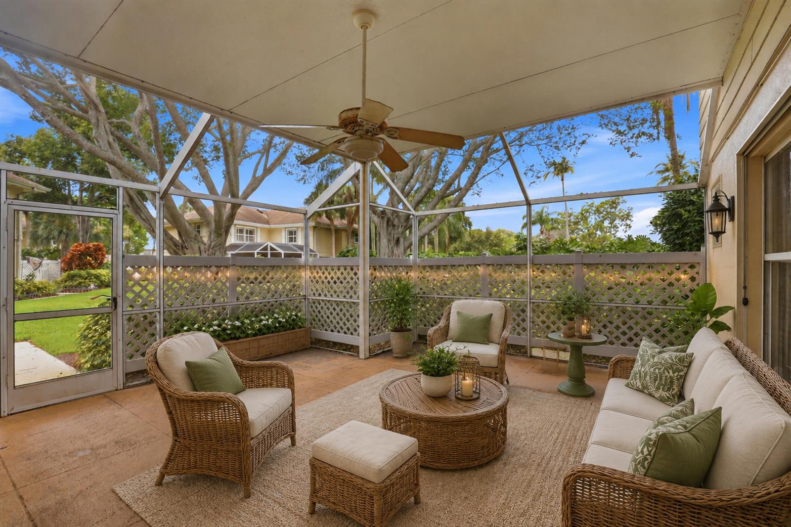 A screened-in patio features wicker furniture, a ceiling fan, and a lattice fence — 6604 Dryden Court # D, Boynton Beach FL 33436, BOYNTON BEACH, FL