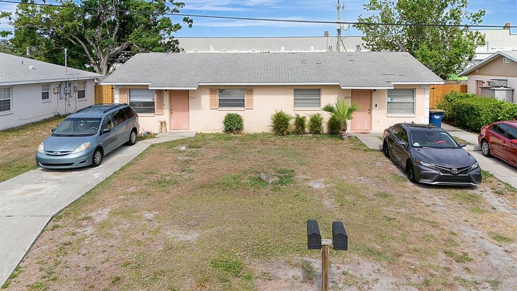 A single-story duplex with a light-colored exterior, two front doors, and two parked cars — 6524/6526 12TH STREET W, BRADENTON, FL