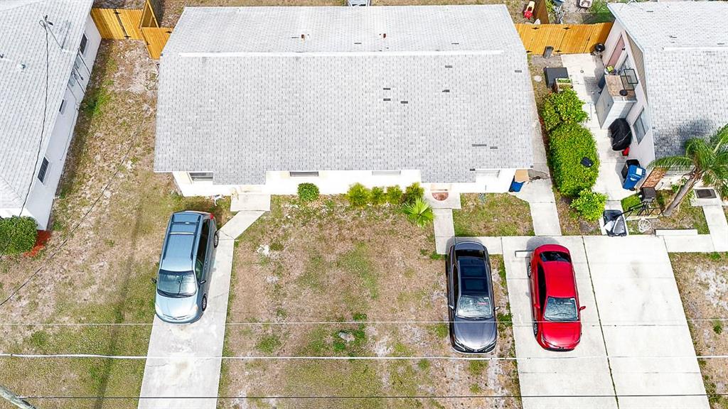 An aerial view shows a single-story house with a gray roof and three parked cars — 6524/6526 12TH STREET W, BRADENTON, FL