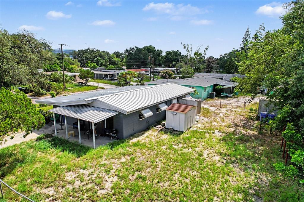 An elevated exterior view of a gray single-story house with a metal roof and shed — 4503 N 72ND STREET, TAMPA, FL