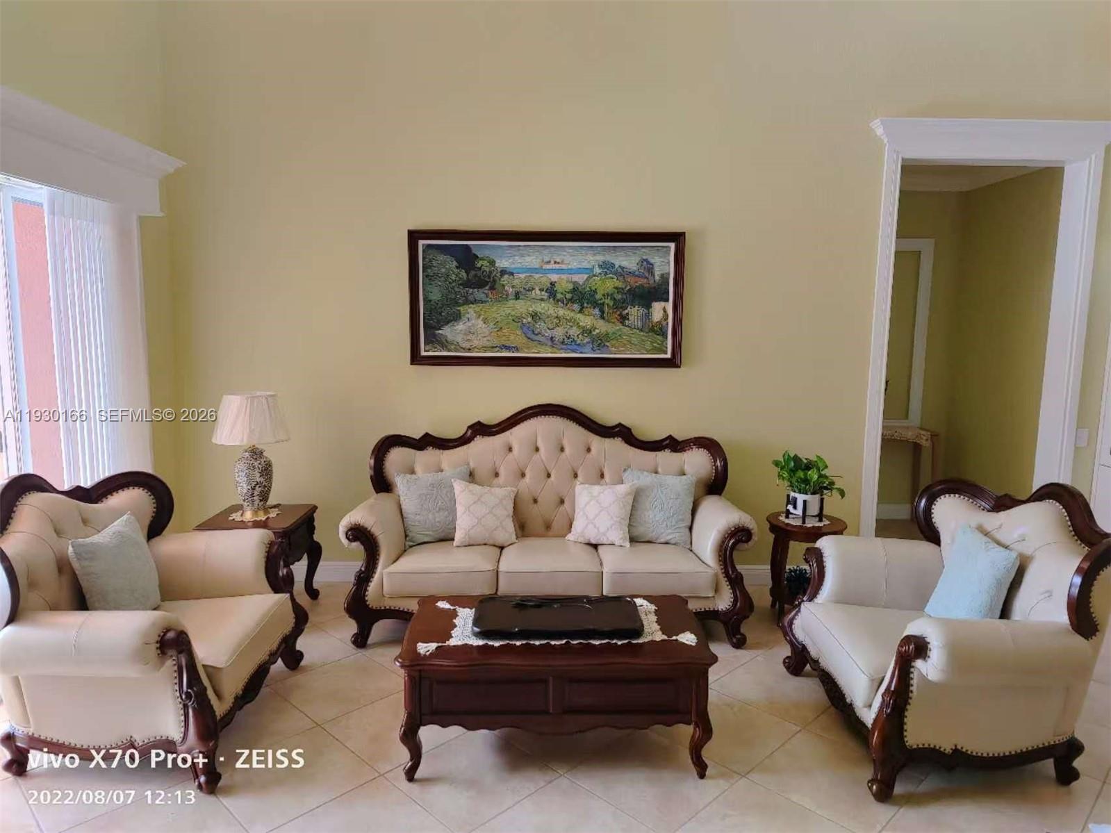 A living room features a cream-colored tufted sofa set, a coffee table, and wall art — 1035 Waterside Cir, Weston FL 33327, WESTON, FL