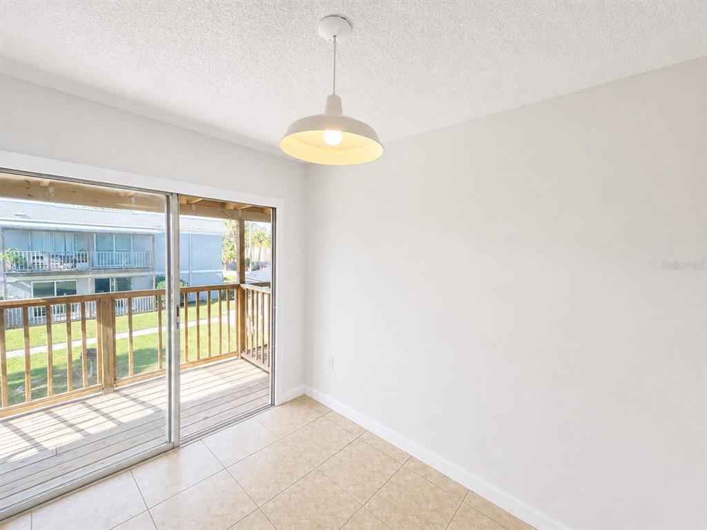 A dining area features tile flooring, a pendant light, and a sliding door to a balcony — 2759 L B MCLEOD ROAD UNIT C, ORLANDO, FL
