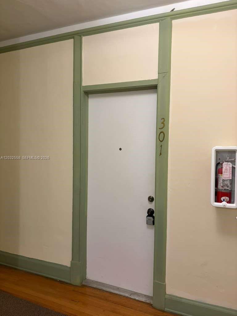 A white door labeled 301 is framed by green trim in a room with beige walls — 900 16th St # 301, Miami Beach FL 33139, MIAMI BEACH, FL