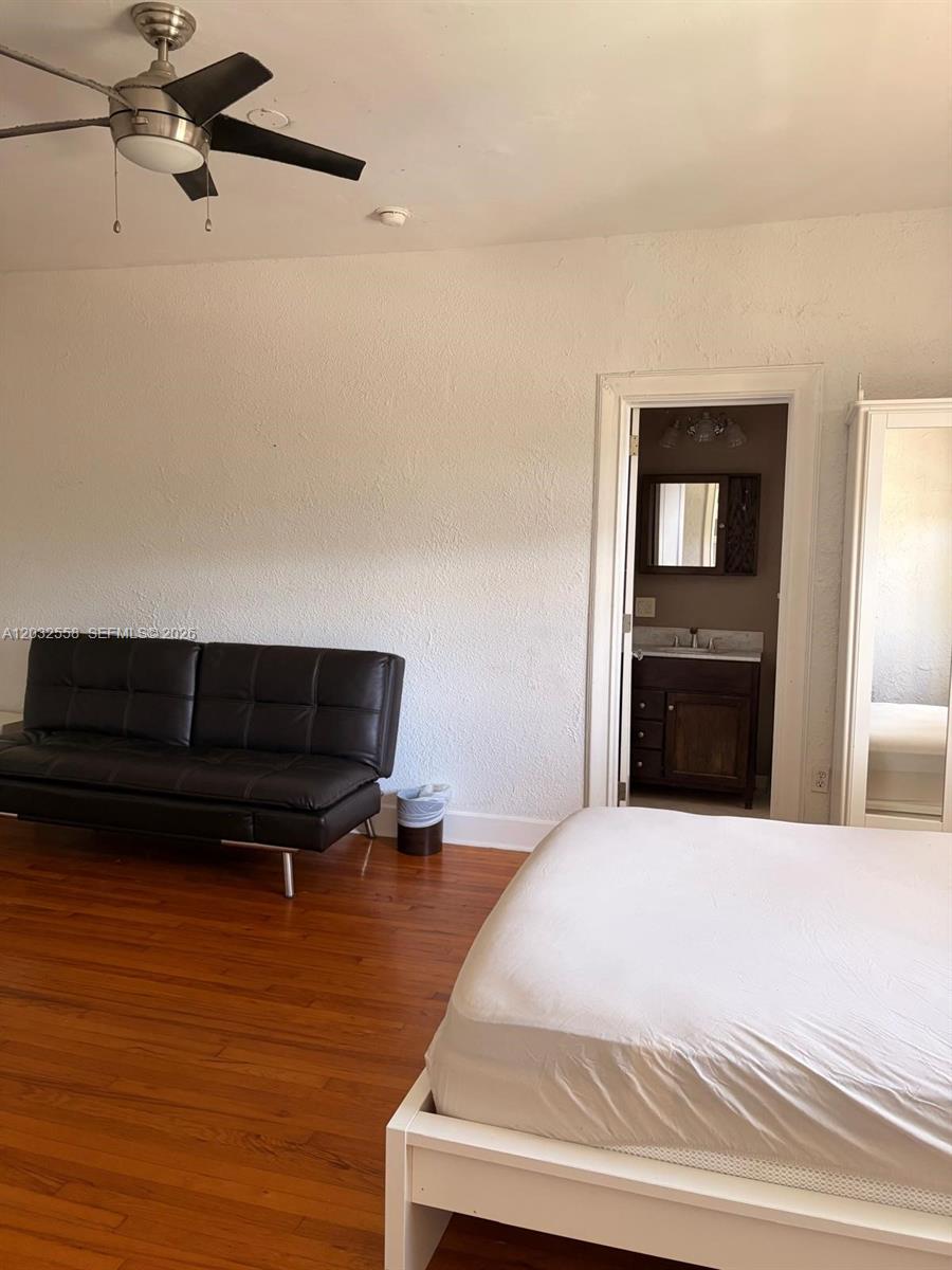 A bedroom features a black futon, a white bed frame, and an attached bathroom — 900 16th St # 301, Miami Beach FL 33139, MIAMI BEACH, FL