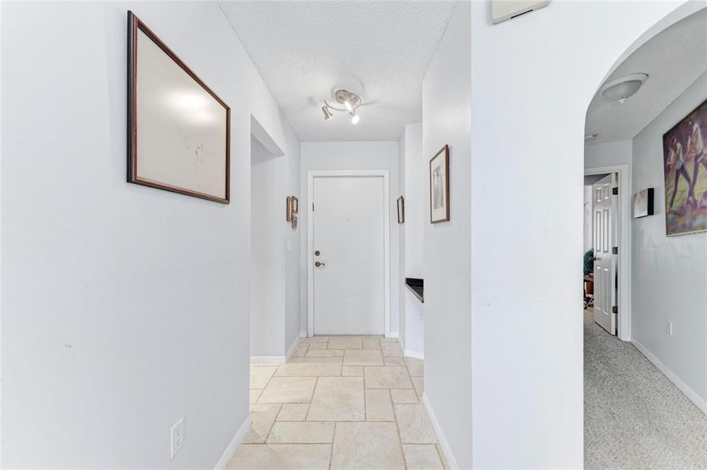 A tiled entryway leads to a white front door under a modern ceiling light fixture — 6101 34TH STREET W UNIT 11G, BRADENTON, FL