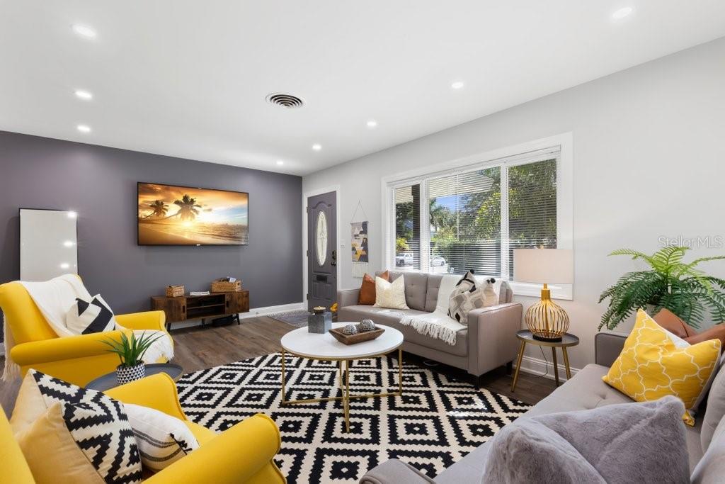 A living room features gray walls, a geometric rug, yellow armchairs, and a gray sofa — 2120 1ST STREET N, ST PETERSBURG, FL