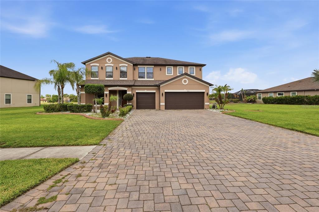 A two-story house with a paved driveway, two garage doors, and a green lawn — 9410 LISBON STREET, SEFFNER, FL