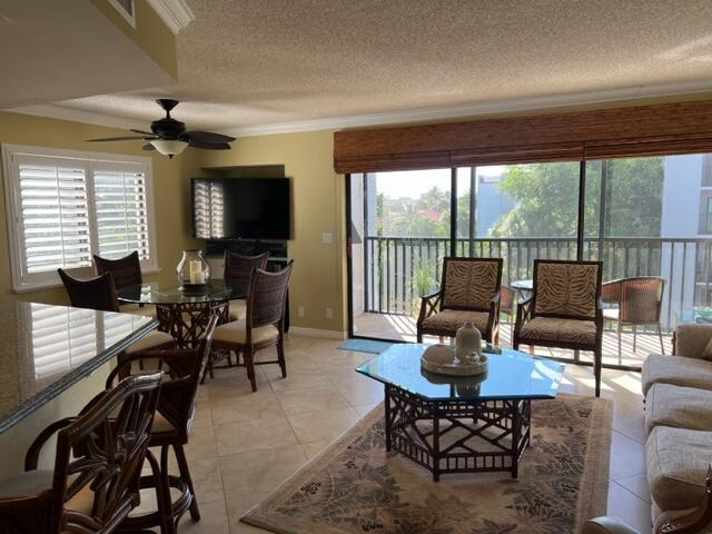 A living and dining area with tile floors, wicker furniture, and a balcony with outdoor seating — 1605 S Us Highway 1 # A301, Jupiter FL 33477, JUPITER, FL