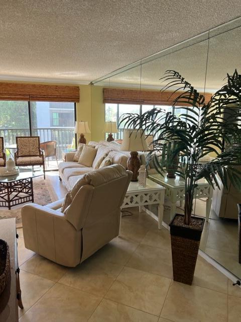 A living room features a beige recliner, sofa, mirrored wall, and a large potted plant — 1605 S Us Highway 1 # A301, Jupiter FL 33477, JUPITER, FL
