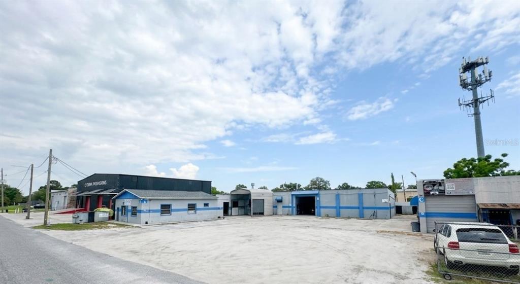 A view of a commercial property with multiple industrial buildings and a large parking lot — 4120 ROUSH AVENUE, ORLANDO, FL